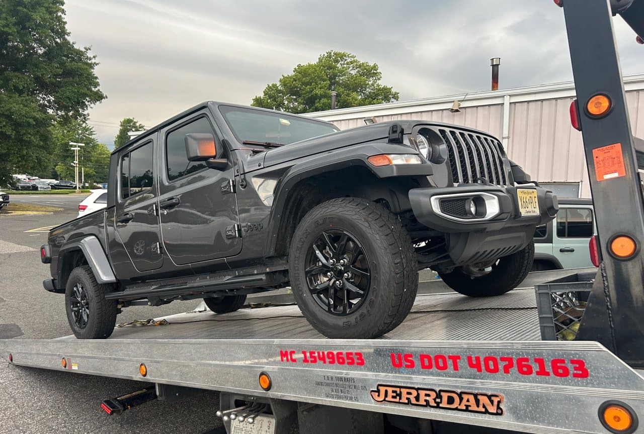Road Heroes professional flatbed tow truck carrying a Jeep Gladiator for 24/7 towing in Central NJ