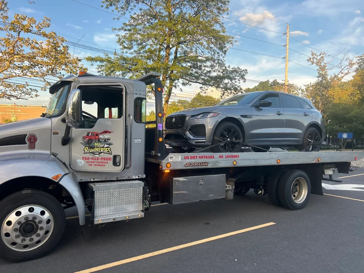 Road Heroes professional flatbed tow truck with Jaguar SUV - 24/7 towing service in Central NJ